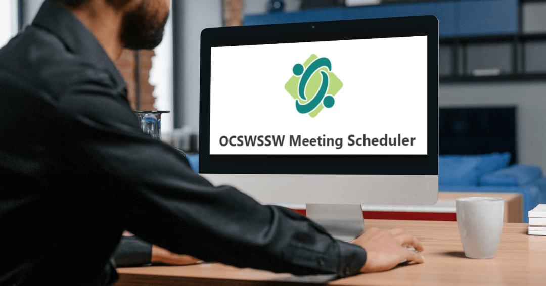 Man looking at a computer screen where it reads OCSWSSW Meeting Scheduler